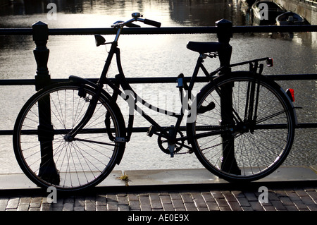 Pedale tradizionale bicicletta sul ponte sul canale di Amsterdam, Olanda Foto Stock