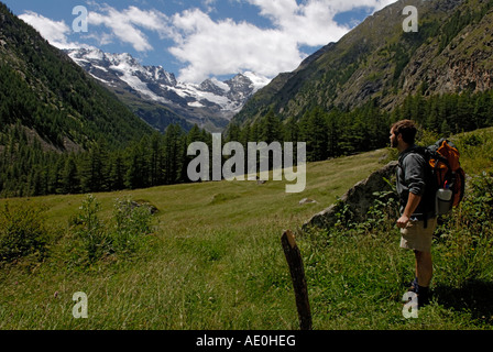 Backpacker, Escursionista, maschio, guardando il panorama alpino, il Parco Nazionale del Gran Paradiso, Alpi Italiane Foto Stock