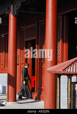 Un monaco entra in un tempio a Yonghe Lamasery Pechino Cina Asia Foto Stock