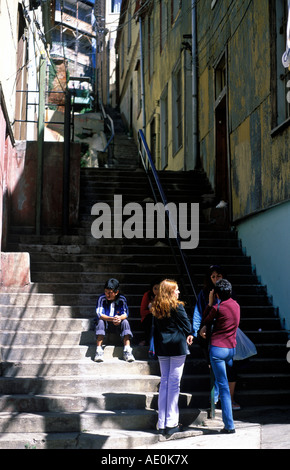 I giovani si riuniscono a gradini che conducono su per la collina fino alla zona del Cerro Alegre, Valparaiso. Foto Stock