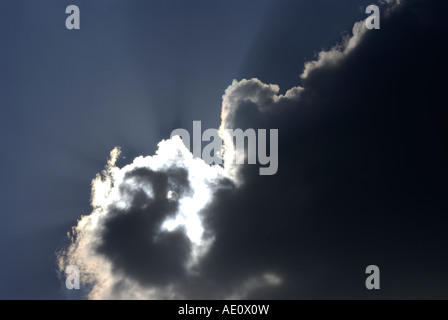 Il sole scompare dietro a passando per il cloud. Foto Stock