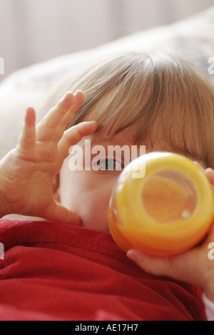 Bimbo a bere da una bottiglia Foto Stock