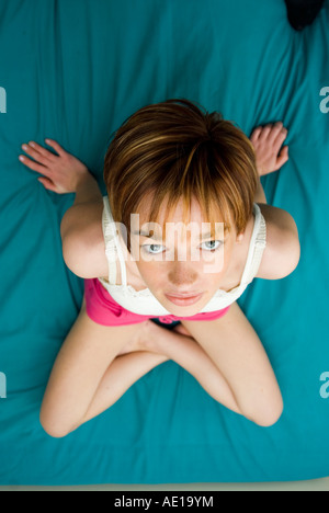 Skinny donna seduta sul letto Foto Stock