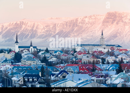 Islanda Reykjavik vista in elevazione oltre le chiese e la città di Reykjavik con uno sfondo di montagne innevate Foto Stock