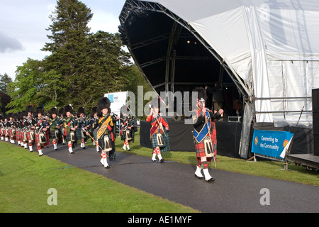 Prestazioni di Ballater tubazione scozzese marching band di musicisti con kilts & plaid presso il Castello di Balmoral serata musicale, Scozia, Aberdeenshire Regno Unito Foto Stock