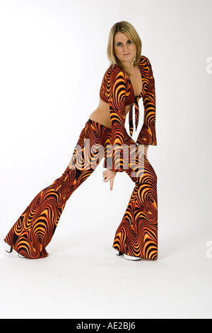 Ragazza bionda che indossa degli anni settanta outfit contro uno sfondo bianco, ritratto Foto Stock
