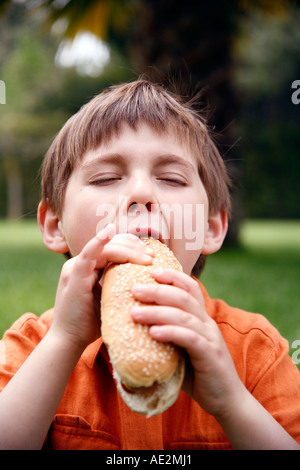 Ragazzo di mangiare un hot dog Foto Stock