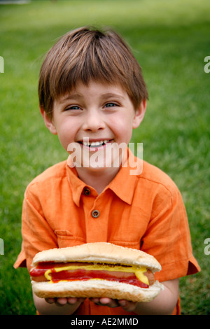 Little Boy tenendo un hot dog Foto Stock