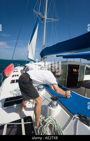 Skipper lavorando su un catamarano di lusso in acque tropicali delle isole Figi nel Pacifico del Sud Foto Stock