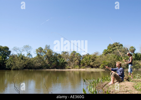 Due figure maschili la pesca in lago del Pantanal, Brasile Foto Stock