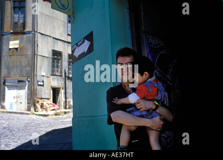 Un giovane Padre tiene il suo figlio in un negozio porta a Valparaiso, Cile. Foto Stock