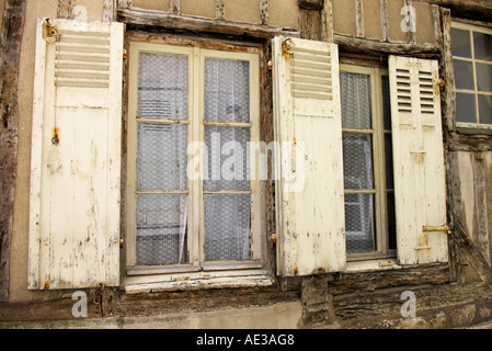 Color crema e marrone e weathered finestre con persiane in Chartres Francia Foto Stock