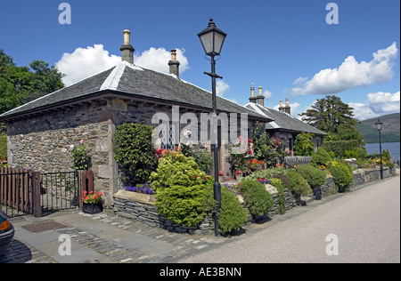 Tradizionali abitazioni in pietra vicino al molo di Luss sul Loch Lomond in Scozia Foto Stock