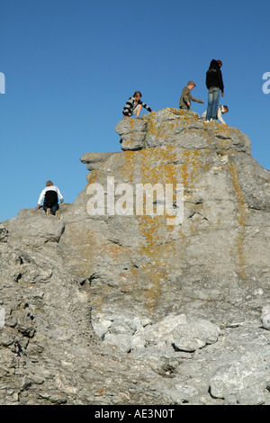 Persone che salgono sul mare naturale pile in Fårö, Gotland chiamato Rauks. Questi sono a Digerhuvud Foto Stock