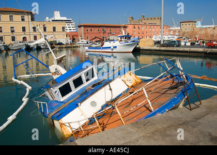 Livorno, Toscana, Italia. La pesca in barca semi affondata nel porto di La Fortezza Vecchia (- 16thC) Foto Stock