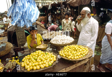 India Goa Vasco de Gama uomo musulmano con ragazzo bere tè chai in stallo vegetale Foto Stock