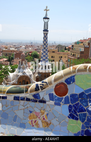 Dettaglio della parete a mosaico in Parc Guell Barcellona Spagna con vista sulla casa del fungo e blue tower Foto Stock