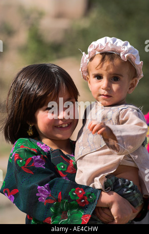 Aimaq ragazza con baby, Pal-Kotal-i-Guk, tra Chakhcharan e marmellata, Afghanistan, Asia Foto Stock