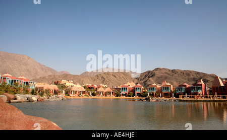 La laguna di acqua di mare al hyatt regency hotel a Taba Heights Red Sea Resort in Egitto con le montagne del Sinai in background Foto Stock