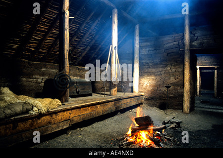 Un incendio illumina il all'interno di una zolla longhouse al XI secolo insediamento vichingo sito di L'Anse aux Meadows, Terranova Foto Stock