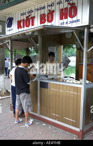 Gli uomini comprano quotidiani in edicola ed ufficio postale nel centro di Hanoi Vietnam Foto Stock