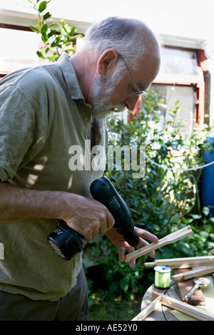 Chris Slade apicoltore la foratura delle barre laterali di frame per essere "cablato" con la lenza dalla bobina nella fotografia. Foto Stock