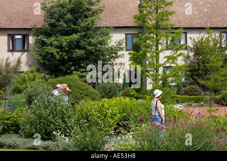 I VISITATORI DI RHS Garden HYDE HALL,vicino a Chelmsford, a piedi nella parte anteriore della vecchia casa colonica che ospita la Biblioteca del giardino Foto Stock