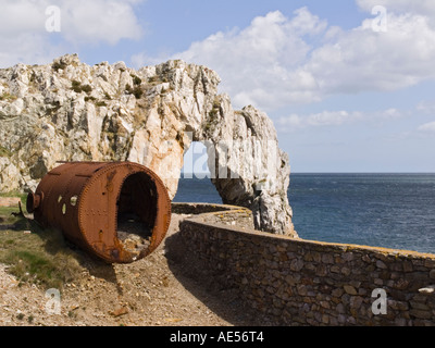 Rusty caldaia e roccia naturale arch a rovinato resti di Porth Wen laterizi da Bay sulla costa di Anglesey. Isola di Anglesey Foto Stock