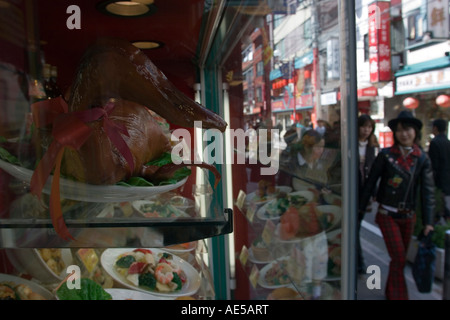 La gente a piedi da una finestra che visualizza il cibo cinese in un ristorante di Chinatown a Yokohama, Giappone Foto Stock