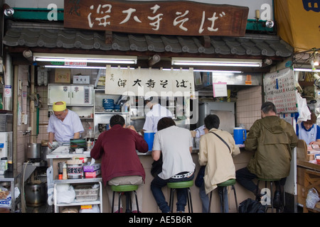 Piccolo ristorante in stallo serve la colazione Giapponese cibo ai clienti nella parte più esterna del mercato Il mercato del pesce di Tsukiji a Tokyo Foto Stock