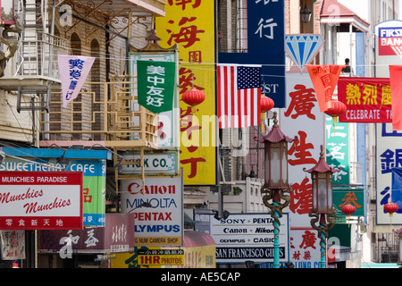 Visual cacofonia delle bandiere cartelli e striscioni in lingua cinese e inglese lettere sulla strada trafficata in San Francisco Chinatown Foto Stock