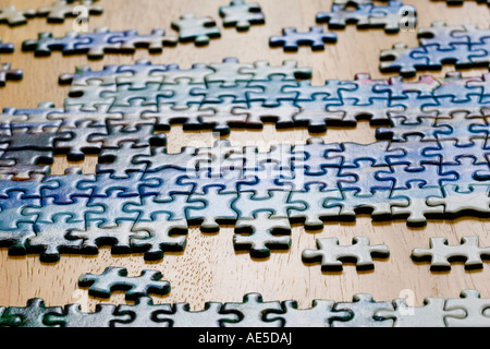 Pezzi di puzzle messi insieme su un tavolo Foto Stock