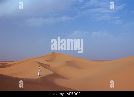 Tourist salendo su una duna di sabbia nel deserto del Sahara in Marocco Foto Stock