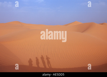 I turisti a scalare una duna di sabbia nel deserto del Sahara in Marocco Foto Stock