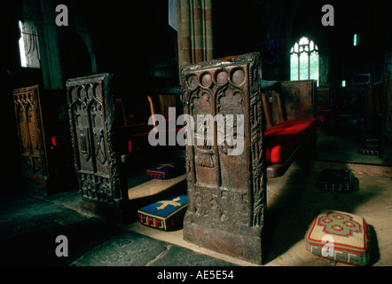 Ornato di legno antico banchi intagliati e tappezzerie di pastiglie in ginocchio St Keverne Chiesa Parrocchiale Cornwall Inghilterra Foto Stock