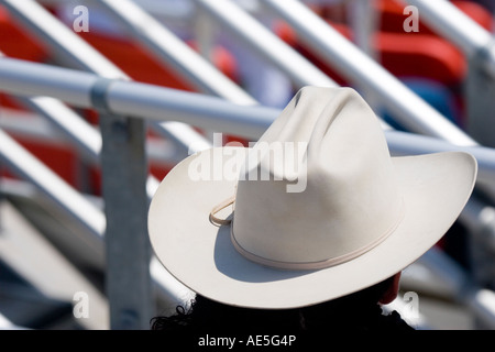 Feltro di Bianca Cappello da cowboy di persona seduta nel sta guardando un rodeo. Foto Stock