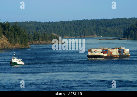 Rimorchiatore tirando chiatta gigante riempito con box di carico verso il basso il passaggio interno della Columbia britannica in Canada Foto Stock