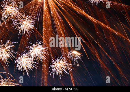 Flussi di fuochi d'artificio arancione frizzante e scintillante nel cielo notturno Foto Stock