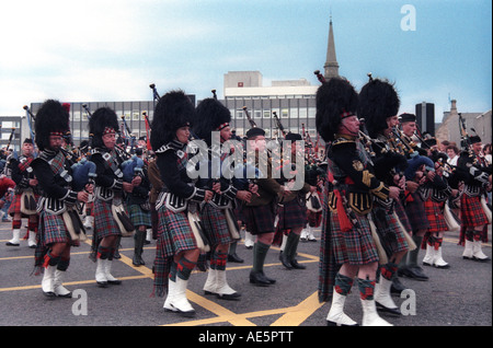 Scottish parade con persone marciando durante la riproduzione di cornamuse e indossano kilts sporrans e abito tradizionale Foto Stock