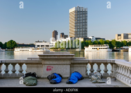 Quattro senzatetto lungo il Victoria Embankment del Tamigi a Londra. Foto Stock