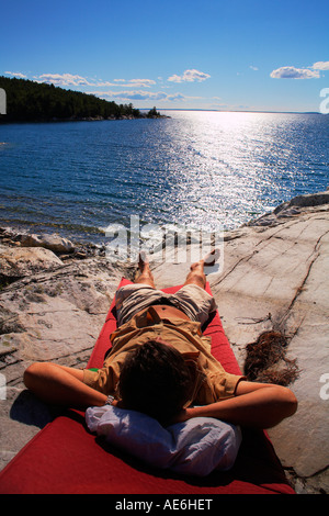 L'uomo rilassante in sun Killarney Provincial Park Ontario Canada Foto Stock