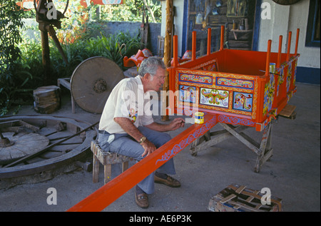 Una Costa Rican artigiano vernici a mano di un tradizionale carrello di bue al famoso Ox Carrello fabbrica nel villaggio di Sarchi, Costa Rica. Foto Stock