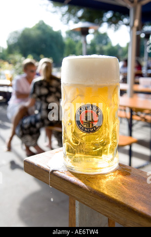 Una tazza grande di bianco Paulaner la birra in un giardino della birra Foto Stock