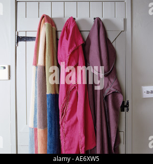 Gli asciugamani e le vestaglie appeso sulla porta di legno Foto Stock
