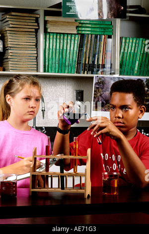 Gli studenti girl e black african american boy età 13 in ottava classe apprendimento delle scienze apprendimento sul banco del laboratorio Foto Stock