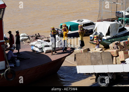 Lavoratori malese per lo scarico di prodotti alimentari trasformati e beni di consumo da imbarcazioni, Batang Rajang River, Kapit, Sarawak, Borneo, Malaysia Foto Stock