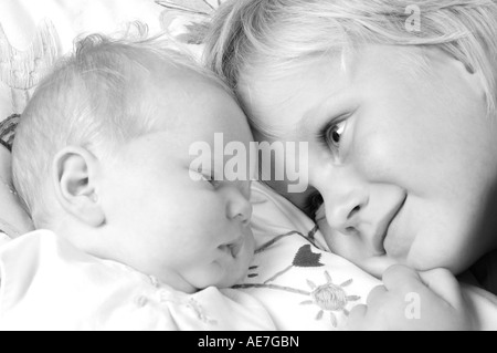 Immagine di un fratello maggiore cerca amorosamente a sua sorella Baby Foto Stock