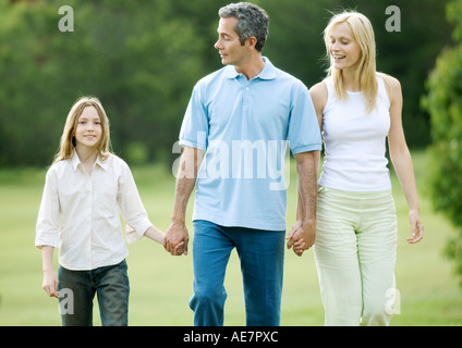 Ragazza tenendo a piedi con i genitori Foto Stock