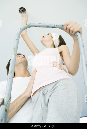 Uomo con l uomo sulla scala come essa cambia lampadina
