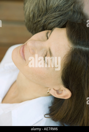 Donna seduta con la testa indietro accanto all uomo, close-up, ritratto Foto Stock